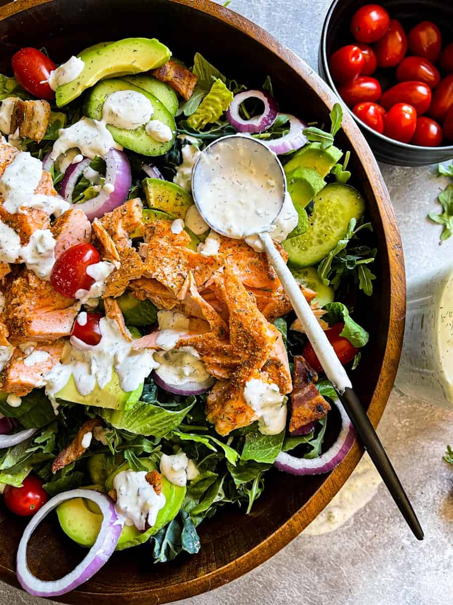 close up of green salad with baked salmon with quick creamy dill pickle ranch salad dressing