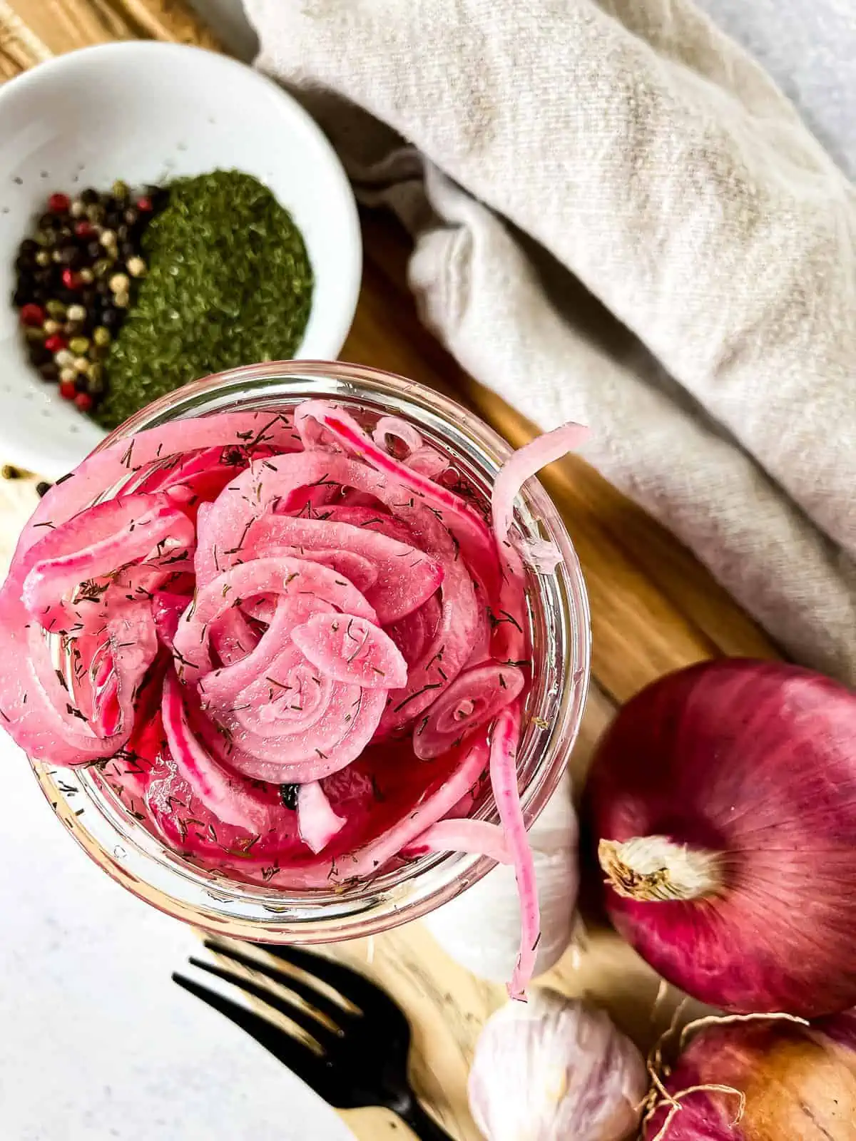 pickled red onions in a jar with ingredients to the side