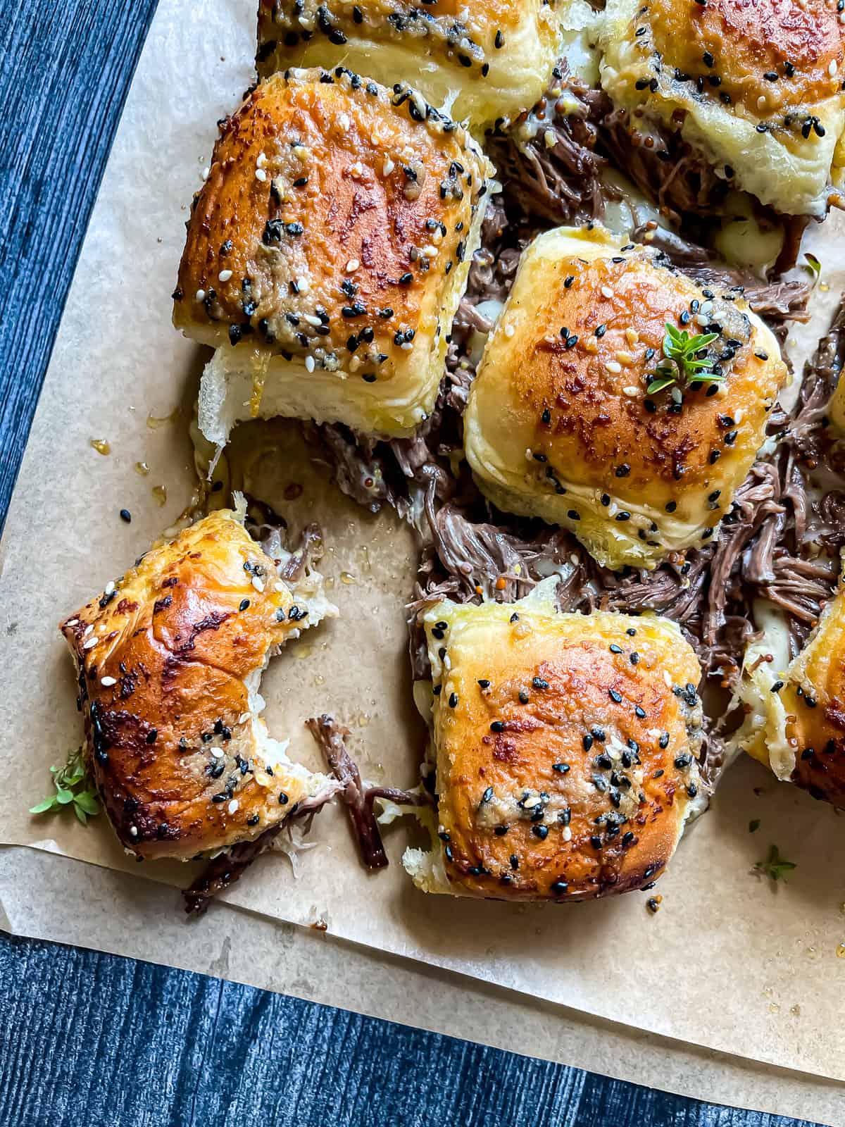 pull apart Instant Pot French Dip Sliders with a bite taken from one of the sandwiches.