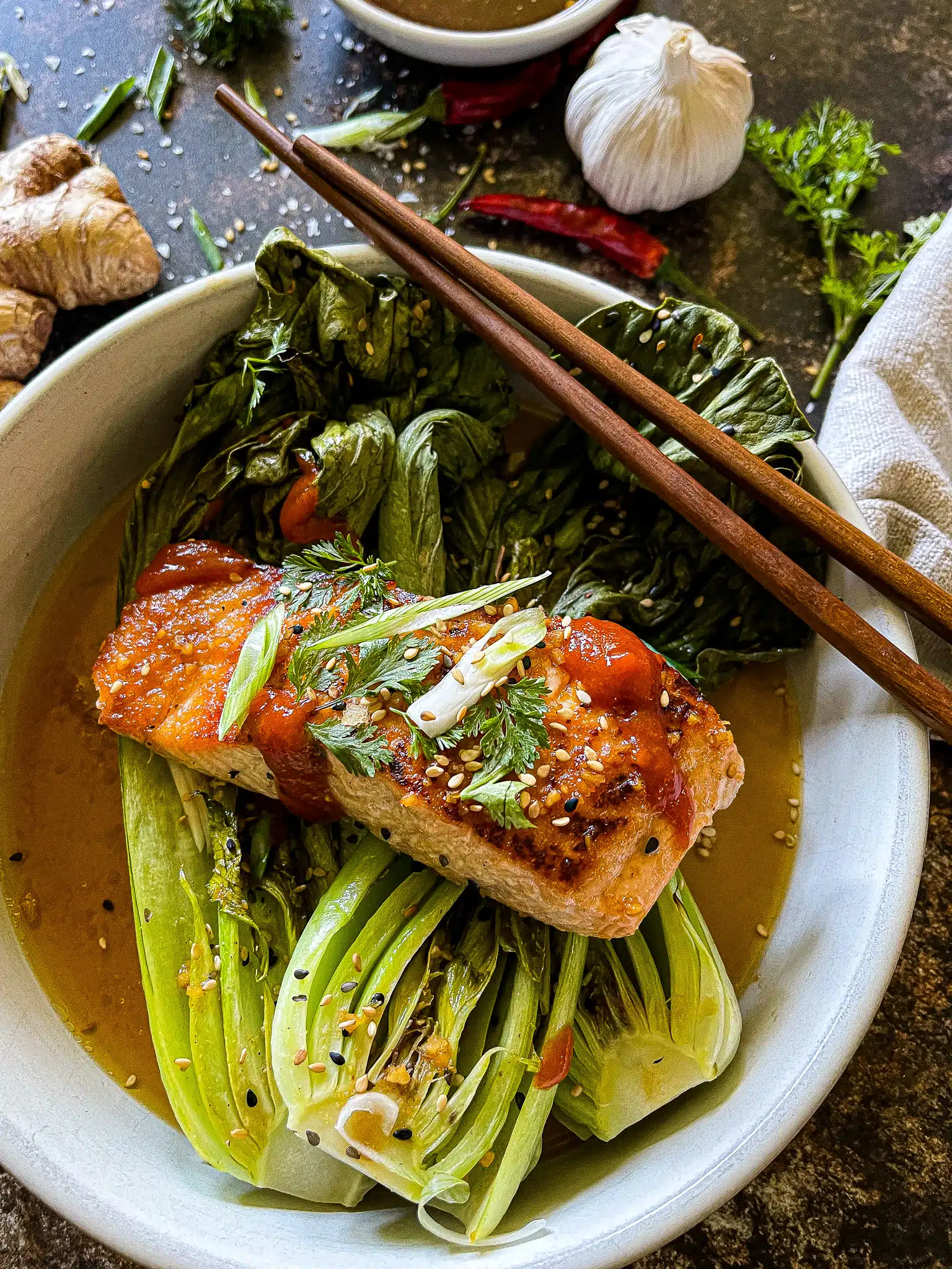 soy ginger salmon served with roasted bok choy, garnished with cilantro, green onion, and sesame seeds