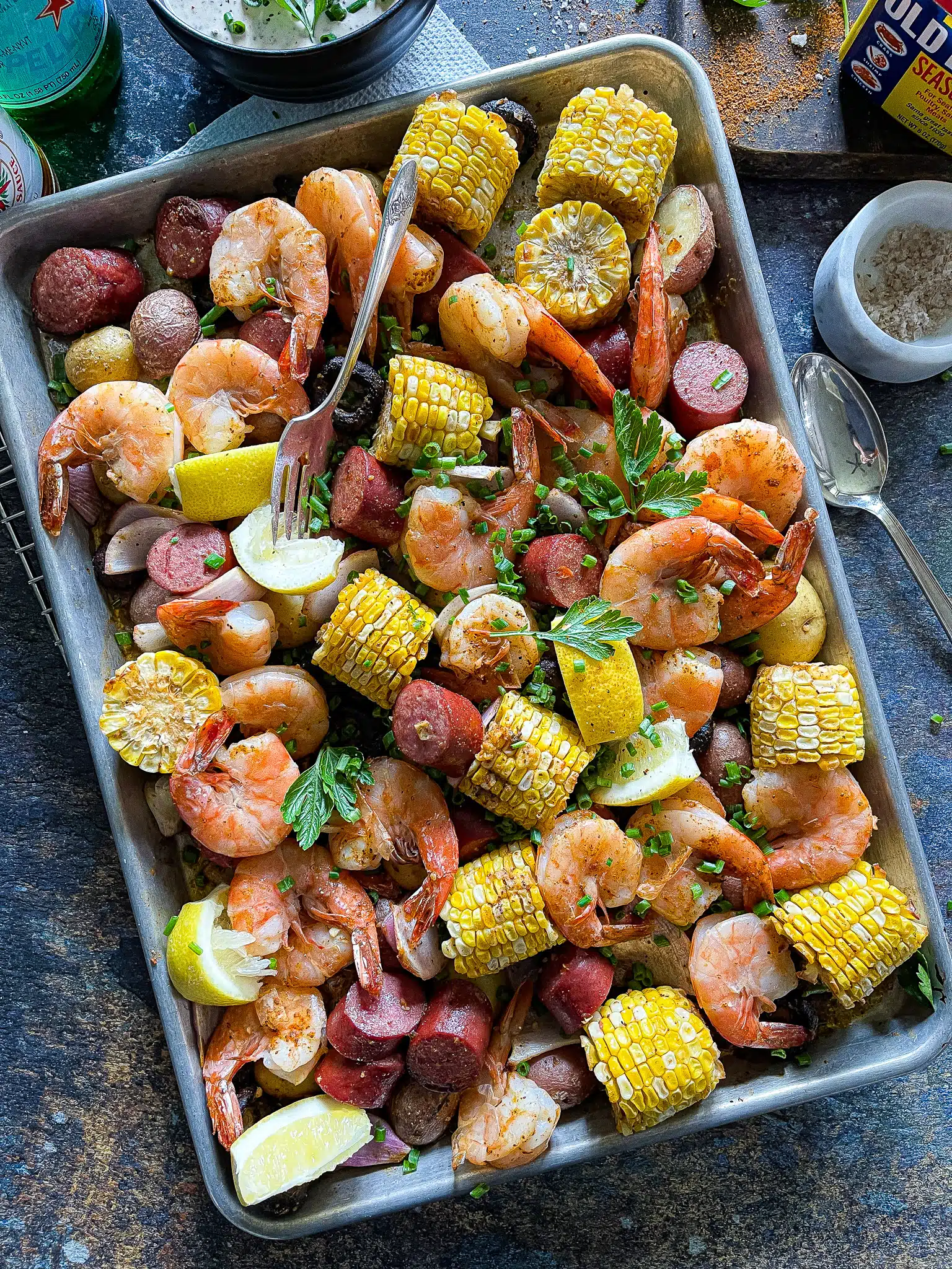 shrimp, potatoes, corn, mushrooms, and sausage roasted on a sheet pan with a side of remoulade