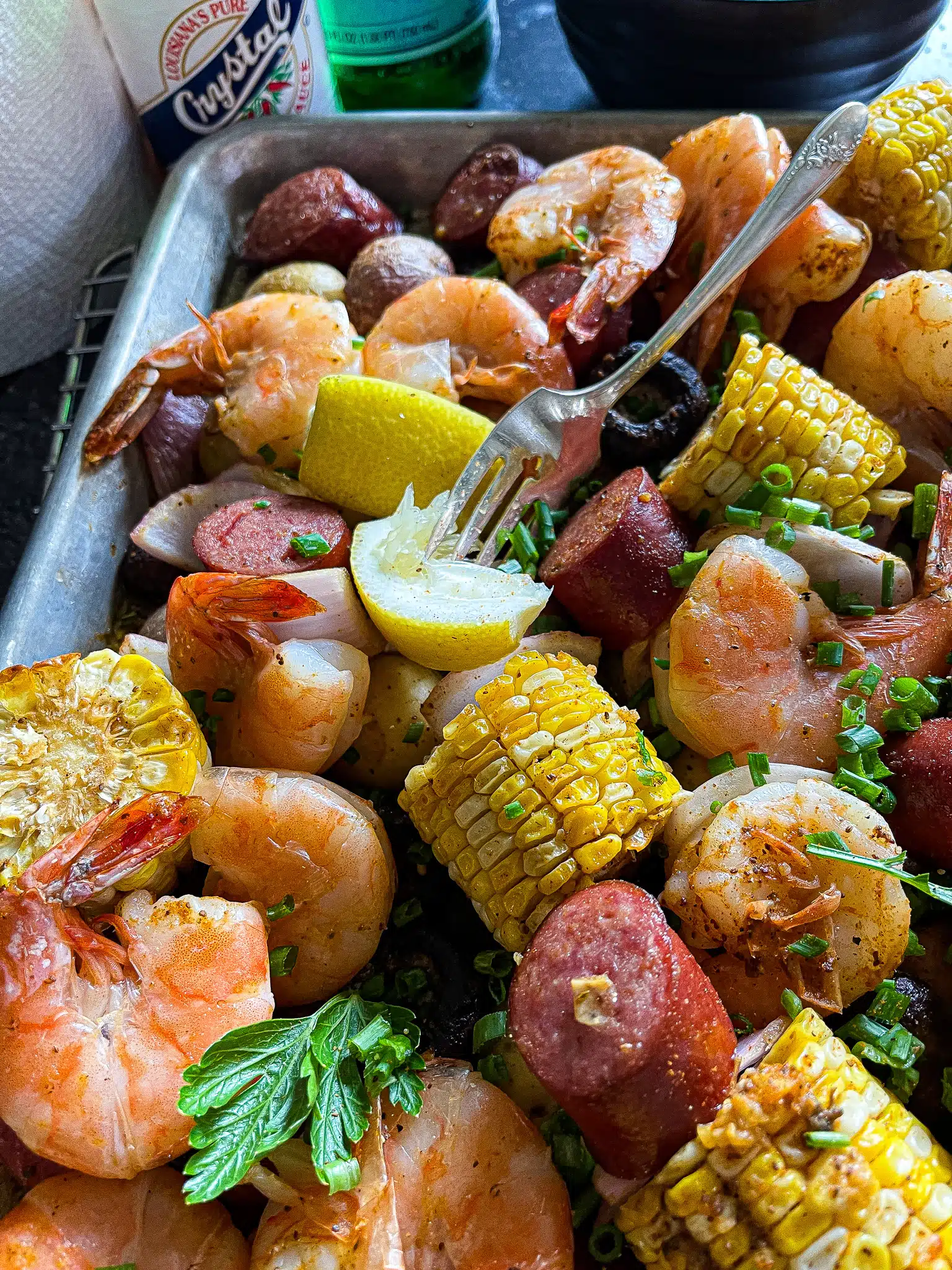 shrimp, potatoes, corn, mushrooms, and sausage roasted on a sheet pan with a side of remoulade